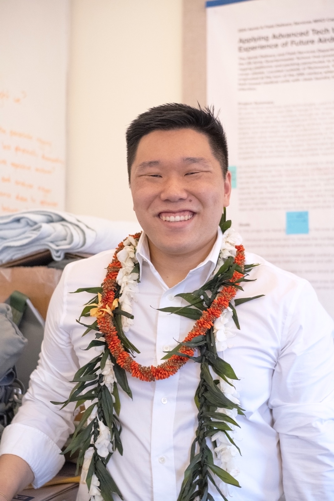 Kyle at his MHCI capstone presentation, wearing graduation leis